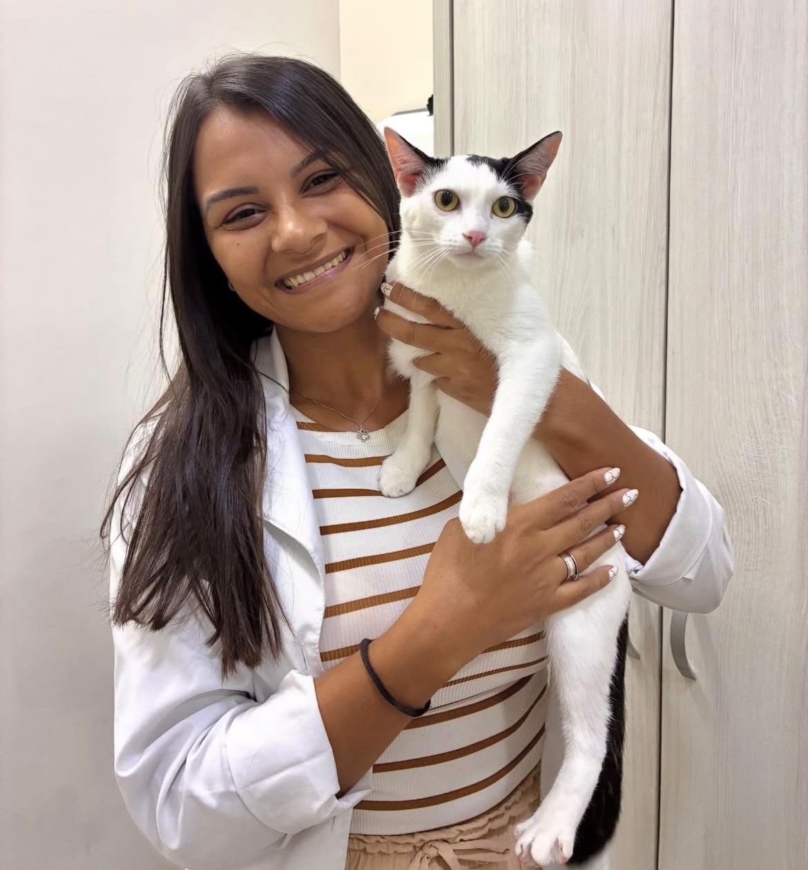 Dra. Isabela Alves segurando um gato branco e preto